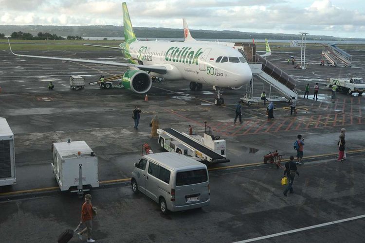 Penumpang bersiap menaiki pesawat udara di Bandara Internasional I Gusti Ngurah Rai, Bali, Rabu (13/12/2017). Aktivitas penerbangan di Bandara I Gusti Ngurah Rai terpantau normal meskipun Gunung Agung terus mengembuskan asap dengan ketinggian hingga 2.000 meter.