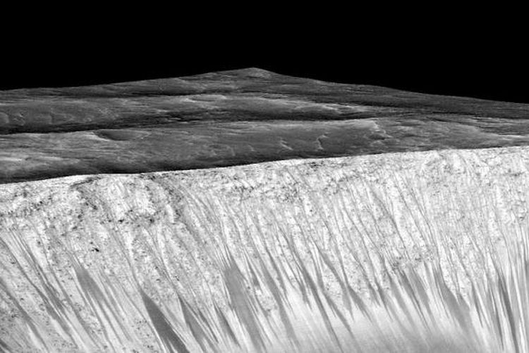 Pola garis gelap sepanjang beberapa ratus meter di tebing di Kawah Garni Mars menjadi bukti keberadaan air saat ini.