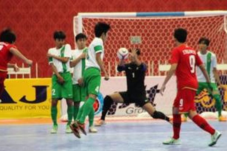 Pemain tim nasional futsal Thailand, Kritsada Wongkaeo (paling kiri), melepaskan tendangan yang dihalau kiper Indonesia, Mohamad Syaldi Aulia Gozali (baju hitam), pada laga semifinal Piala AFF Futsal 2013, di Bangkok Thonburi University, Jumat (25/10/2013).