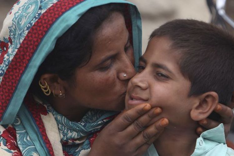 Rehmana Bibi mencium putranya, Ali Raza, yang positif terjangkit HIV. Raza merupakan satu dari lebih dari 400 anak di Pakistan yang terkena HIV.