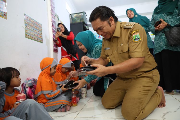 Penjabat (Pj) Gubernur Banten Al Muktabar memberikan makanan bergizi kepada anak-anak dalam peluncuran Gerakan Serentak Cegah dan Tanggulangi Stunting Provinsi Banten di Gedung Kwartir Cabang (Kwarcab) Pramuka Kota Serang, Selasa (11/6/2024).
