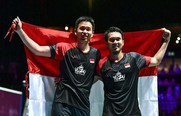 Ganda putra Indonesia Hendra Setiawan (kiri) dan Mohammad Ahsan berpose dengan bendera merah putih usai mengalahkan ganda putra Jepang Takuro Hoki dan Yugo Kobayashi pada babak final Kejuaraan Dunia Bulu Tangkis 2019 di St Jakobshalle, Basel, Swiss, Minggu (25/8/2019). Ahsan/Hendra menjadi juara dunia ganda putra usai menang dengan skor 25-23, 9-21, 21-15.