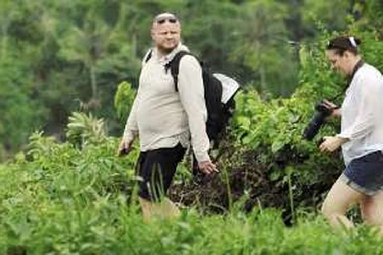 Wisatawan menyusuri persawahan di bawah kaki Gunung Rinjani, Desa Senaru, Kecamatan Bayan, Lombok Utara, Nusa Tenggara Barat, Selasa (26/1/2016). Selain pendakian ke Gunung Rinjani, banyak pesona alam dan budaya di kawasan sekitar menjadi daya tarik wisatawan.