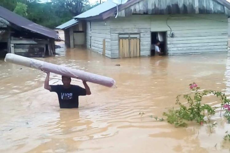 Warga Desa Koneha mencoba menyelamatkan harta benda mereka dari rendaman banjir.