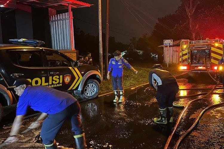 Para petugas Damkar Pemkab Bondowoso membersihkan ceceran solar di Jalan raya Bondowoso-Jember, Kecamatan Maesan, pada Senin (12/5/2025) malam. Akibat tumpahan solar itu, jalan menjadi licin dan banyak pengendara berjatuhan. 

