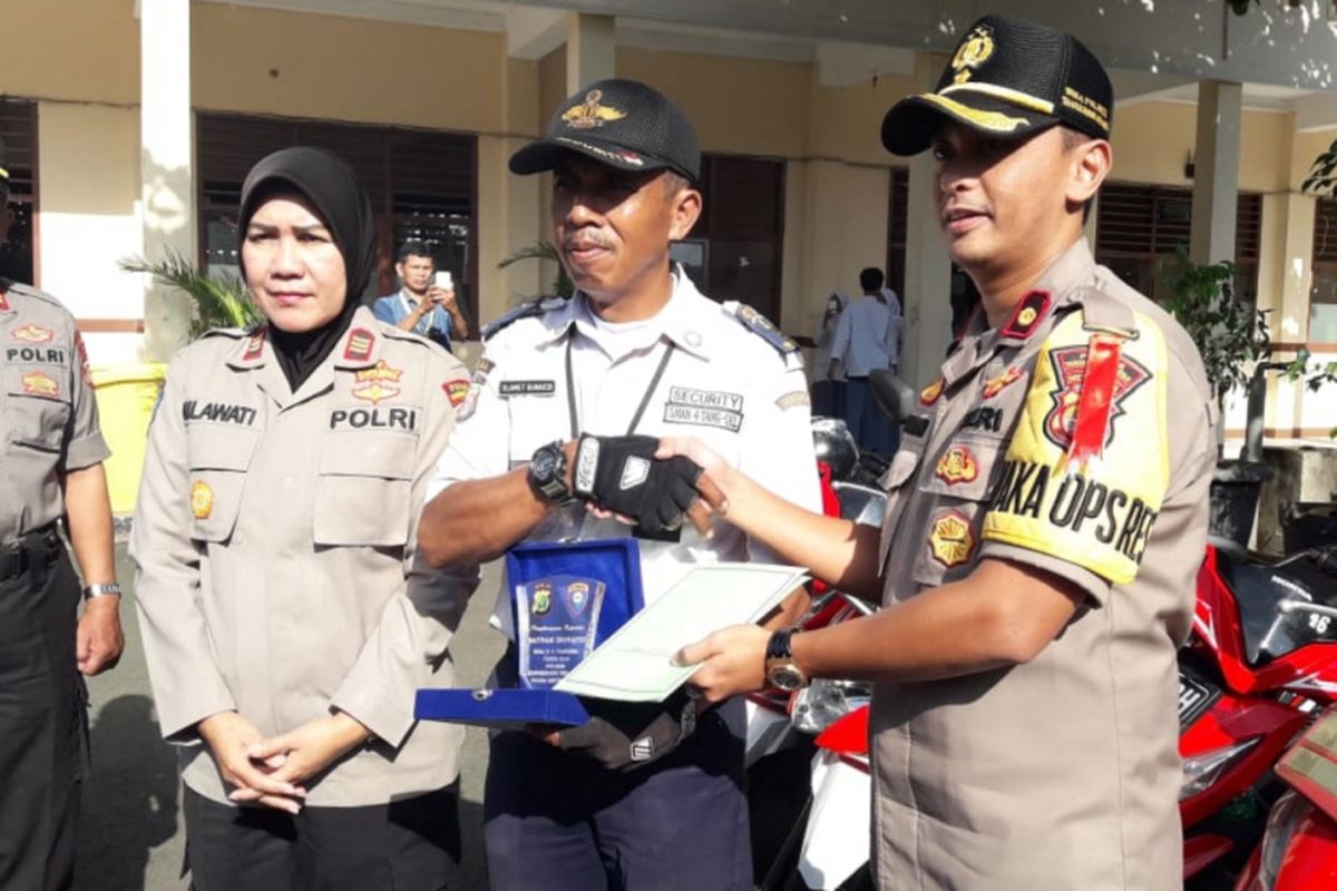 Wakapolres Tangerang Selatan, Kompol Arman saat beri penghargaan kepada Slamet Gunaedi, Satpam SMAN 4 Tangsel yang viral karena parkir motor sesuai warna, Jumat (1/2/2019).
