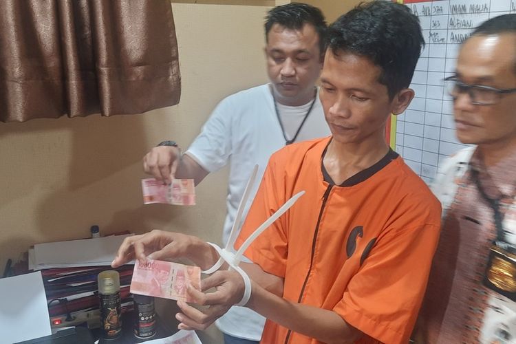 Epin Mayandi (36) tersangka pemalsuan uang ketika berada di Polda Sumatera Selatan, Jumat (18/11/2022). Ia mencetak uang palsu Rp 5 juta untuk membeli handphone serta belanja di warung.