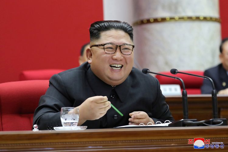 Pemimpin Korea Utara Kim Jong Un tertawa saat menghadisi Pertemuan Umum Kelima Komite Pusat Partai Buruh, dalam foto yang dirilis pada 31 Desember 2019 oleh media pemerintah KCNA.