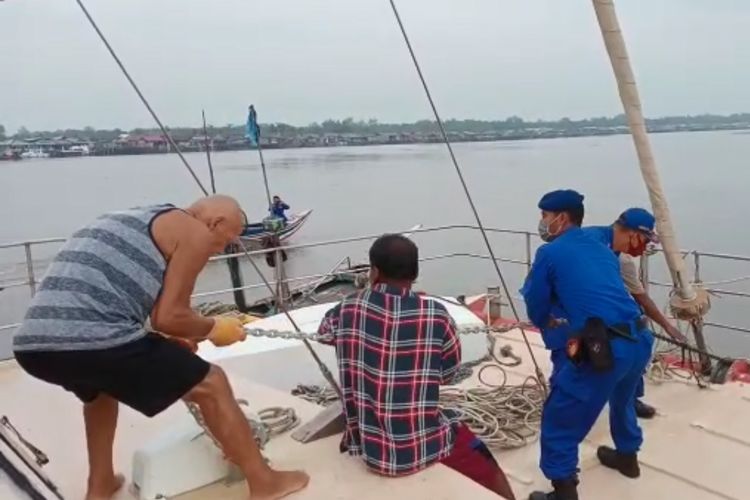 Tadeusz Nowicki (kiri) WNA Australia yang kapalnya dibegal di perairan perbatasan Sumsel - Lampung memersiapkan tali yang diikatkan ke kapal nelayan yang menarik kapalnya, Sabtu (6/6/2020). (FOTO: Dok. Humas Polda Lampung).