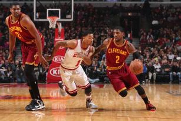 Pebasket Chicago Bulls, Derrick Rose (tengah) berusaha menghadang laju Kyrie Irving (kanan) dari Cleveland Cavaliers, disaksikan Andrew Bynum, saat kedua tim bertemu pada lanjutan kompetisi NBA di United Center, Senin (11/11/2013).