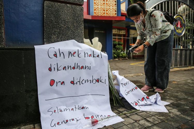 Seorang wartawan mengambil gambar bunga-bunga yang diletakkan untuk dukungan dan doa kepada siswa yang meninggal dunia diduga akibat ditembak oknum polisi di depan SMKN 4 Semarang, Semarang, Jawa Tengah, Selasa (26/11/2024). Aksi yang digelar oleh Aliansi Masyarakat Peduli Kota Semarang tersebut mendorong pihak kepolisian setempat segera mengusut tuntas, berperilaku adil, dan jujur dalam menangani kasus oknum polisi Satnarkoba Polrestabes Kota Semarang berinisial S yang diduga melakukan penembakan yang menewaskan seorang siswa anggota Pasikbra SMK Negeri 4 Semarang pada Minggu (24/11/2024) dini hari di daerah Semarang. ANTARA FOTO/Makna Zaezar/rwa.