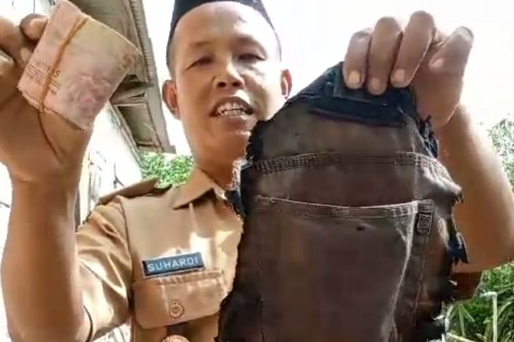 Kepala Desa Sumbermulyo, Suhardi, saat menunjukkan potongan celana yang berisi uang Rp 4 juta, Rabu (24/1/2024).