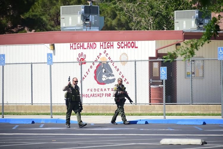 Petugas bersenjata berjaga di sekitar sekolah tinggi Highland di Palmdale, Los Angeles, menyusul insiden penembakan yang terjadi pada  Jumat (11/5/2018).