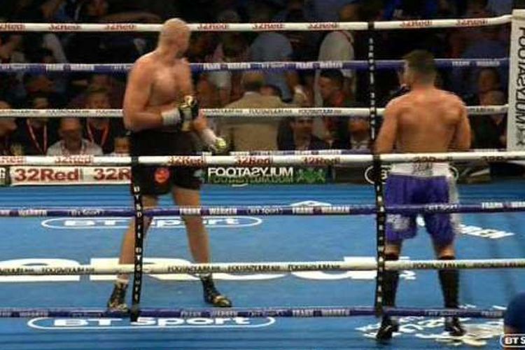 Tyson Fury (kiri) sempat menengok keributan yang terjadi di antara para penonton