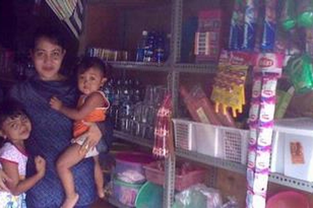 Luh Martini bersama kedua putrinya di warung kelontong yang menjadi penopang hidupnya. Kini nasib usahanya semakin terancam di tengah "mewabahnya" mini market.