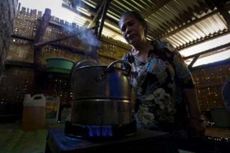 Elisabeth Hadi Rendi memasak air menggunakan kompor yang didukung oleh gas metana yang dihasilkan sistem biogas mini dari kotoran babi di Waingapu, Sumba, 20 Maret 2014.