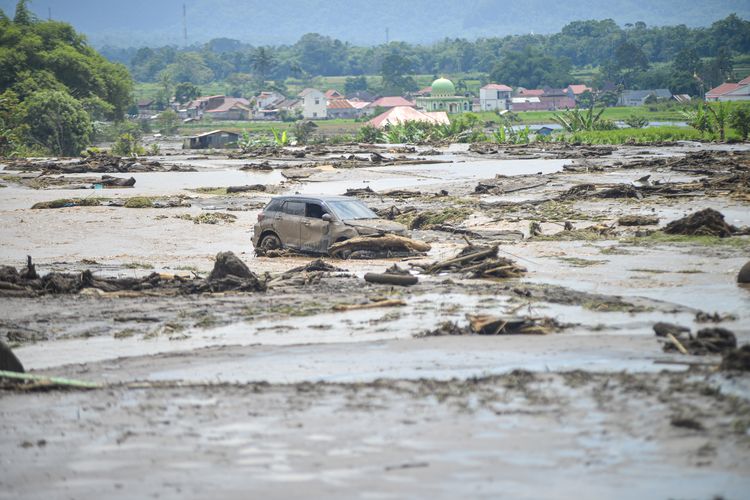 Sebuah mobil yang terdampak banjir bandang di Nagari Bukik Batabuah, Agam, Sumatera Barat, Minggu (12/5/2024). Banjir bandang akibat meluapnya aliran air lahar dingin Gunung Marapi serta hujan deras di daerah itu mengakibatkan 18 tewas, sejumlah rumah rusak dan ratusan warga diungsikan. 
