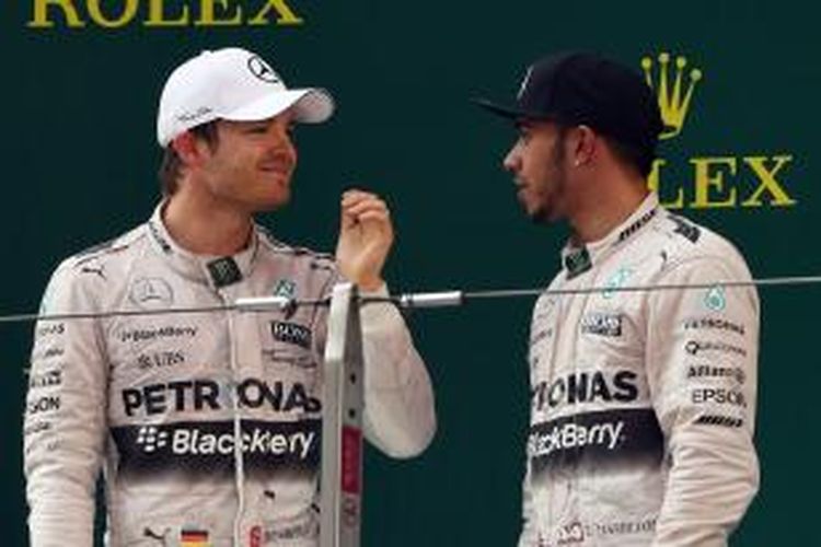 Pebalap Mercedes, Nico Rosberg (kiri) dan Lewis Hamilton, berbicara setelah menyelesaikan balapan GP China di Sirkuit Shanghai, Minggu (12/4/2015).