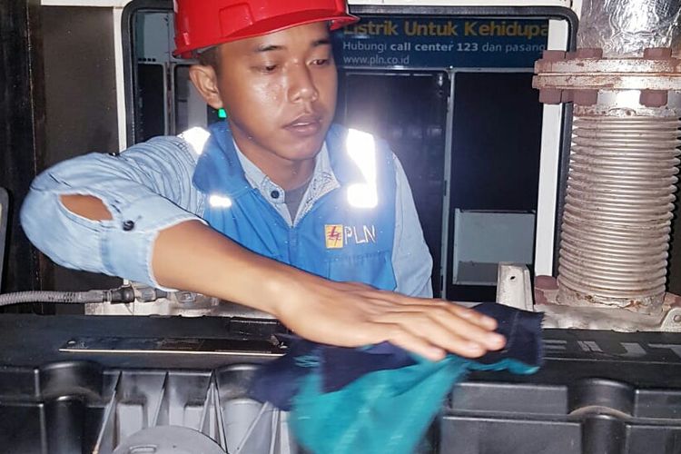 Petugas PLN, Slamet saat membersihkan mesin pembangkit listrik Pulau Gersik, Belitung, Rabu (1/5/2019)