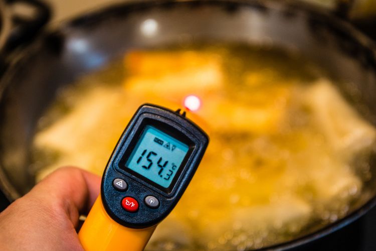 ilustrasi mengecek suhu minyak dengan temperatur agar hasil makanan tidak terlalu lembek. 