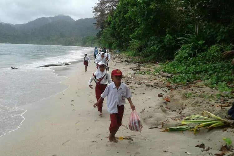 Siswa SD Negeri 11 Seram bagian Timur di Pedalaman Pulau Seram Maluku berjalan menyusuri pantai untuk mengikuti upacara HUT Kemerdekaan RI di Desa Loko, Selasa (17/8/2021)