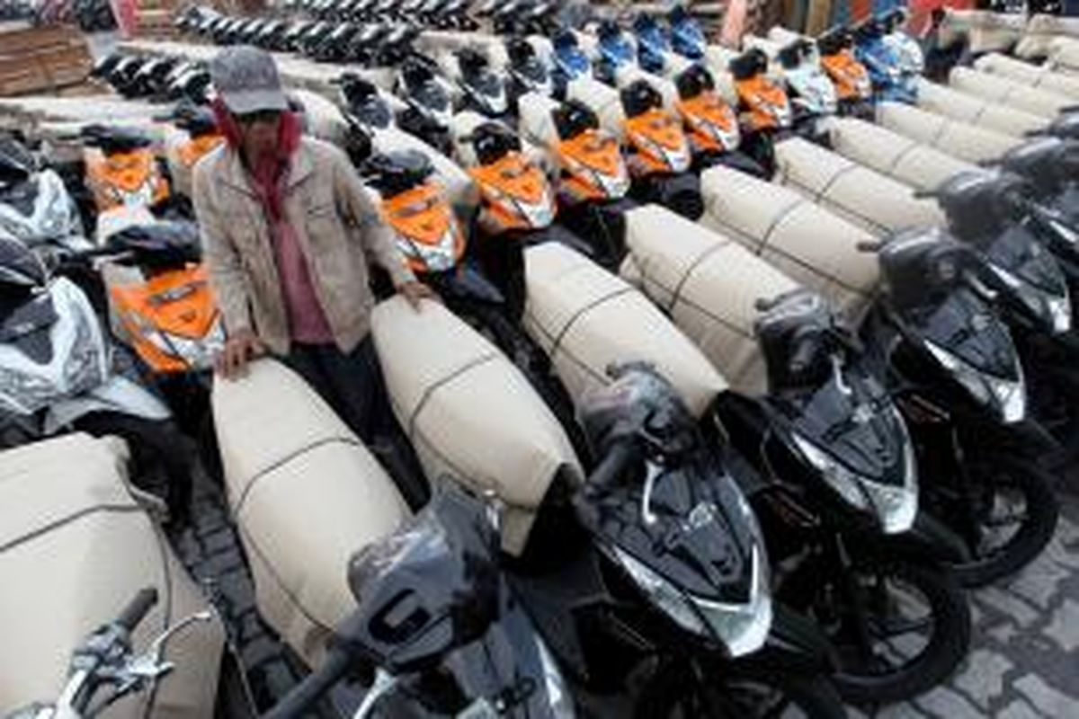 Buruh merapikan sepeda motor skutik Honda untuk dikirim ke Riau di Pelabuhan Sunda Kelapa, Jakarta, Senin (15/4/2013).