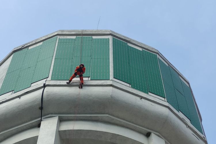 Aksi heroik tim Damkar dari BPBD Kota Pasuruan menyelamatkan drone tersangkut di water toren jadi tontonan warga di sekitar Alun-alun Kota Pasuruan, Jawa Timur, Kamis (11/12/2025). 