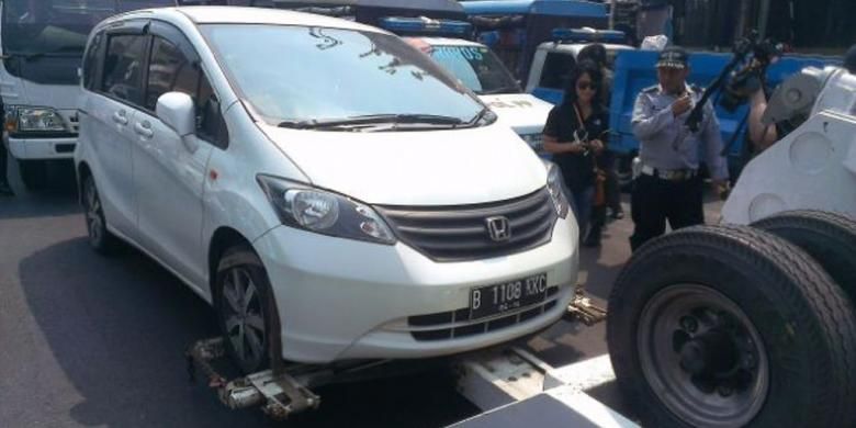Petugas Dishub DKI menderek mobil yang parkir sembarangan di kawasan Tanah Abang, Jakarta Pusat, Senin (8/9/2014).