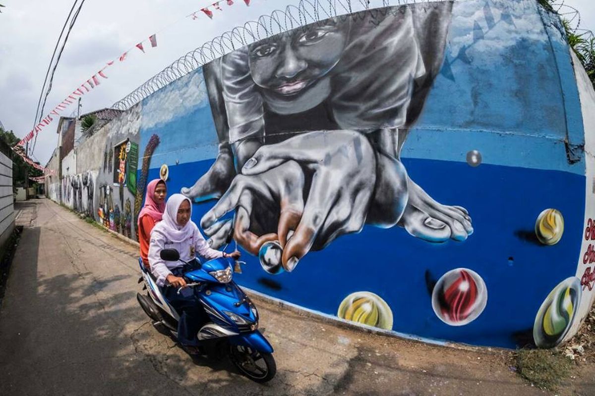 Dua orang warga Rt 04 dan Rw 4, Gang Abdul Jabar melintas di depan dinding-dinding berlabur Mural.