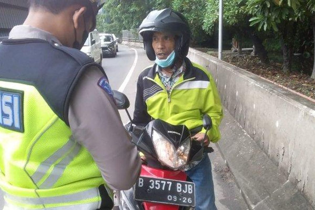 Pengendara motor berinisial P (jaket hijau muda) dihentikan polisi lalu lintas setelah nyasar masuk ke jalan tol lantaran mengikuti petunjuk jalan di aplikasi Google Maps, pada Senin (26/12/2022).