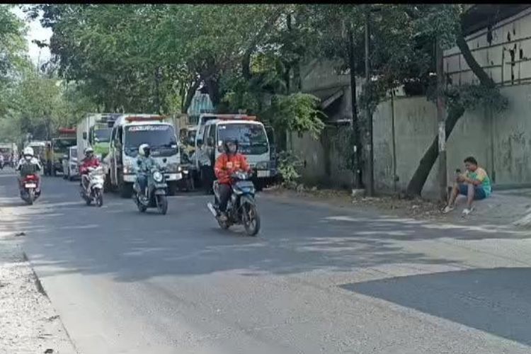 Petugas menderek tujuh truk yang parkir sembarangan di Jalan Peternakan II, Kapuk, Cengkareng, Jakarta Barat, Kamis (15/6/2023).  