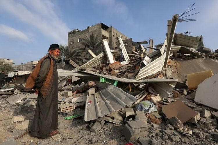 Seorang pria Palestina memeriksa rumah-rumah yang rusak di tengah perang Israel-Hamas di Khan Younis di Jalur Gaza selatan, Selasa (12/12/2023).