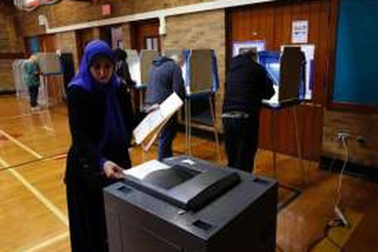 Seorang perempuan Muslim memberikan suara di sebuah TPS di Michigan, Selasa (8/11/2016).