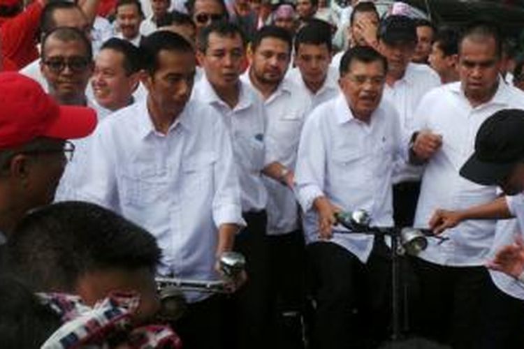 Joko Widodo dan Jusuf Kalla bersepeda menuju Komisi Pemilihan Umum dari kediaman Megawati Soekarnoputri di Teuku Umar, Jakarta, untuk mendaftar menjadi pasangan capres dan cawapres dari PDIP, 19 Mei 2014.