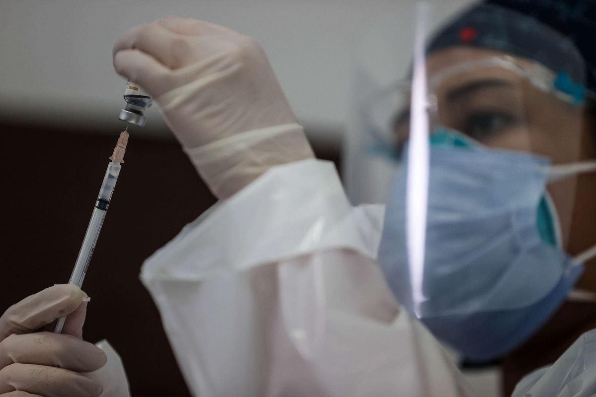 A file photo of a health care worker receiving Covid-19 vaccine from Chinas Sinovac. 