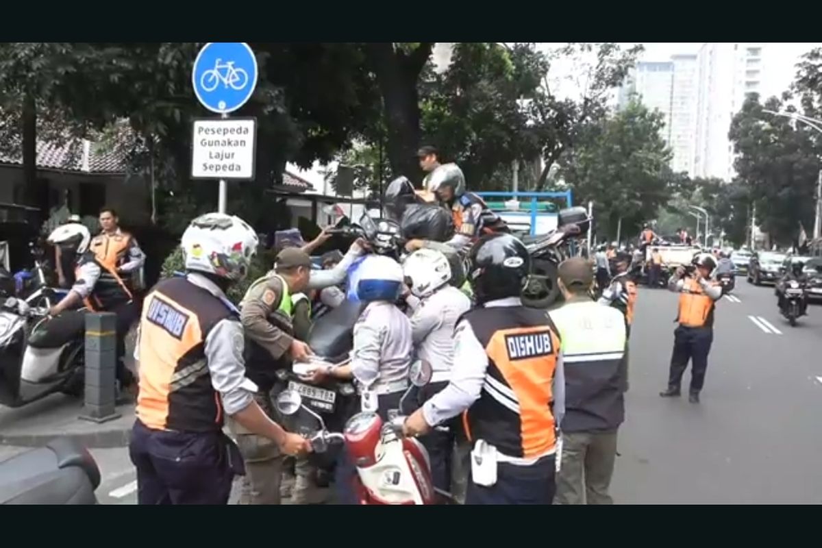 Petugas gabungan menertibkan motor yang diparkiran dipinggir jalan Senopati, Kebayoran Baru, Jakarta Selatan. 