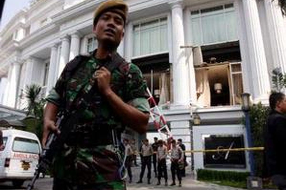 Anggota TNI melakukan penjagan di depan Hotel Ritz Carlton, kawasan Mega Kuningan, Jakarta Selatan, sesaat setelah terjadi ledakan bom, Jumat (17/7). Ledakan yang terjadi di dua hotel yaitu Hotel JW Mariott dan Hotel Ritz Carlton mengakibatkan sedikitnya 6 orang meninggal dan 16 luka-luka. 
