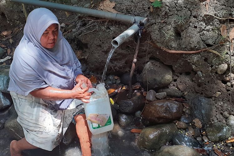 Mama Habiba (54) warga Kampung Ende, Desa Bea Ngencung, Kec. Ranamese, Kab. Manggarai Timur, Flores, NTT sedang menimba air minum di jerigen, Sabtu, (16/11/2019). (KOMPAS.com/MARKUS MAKUR)