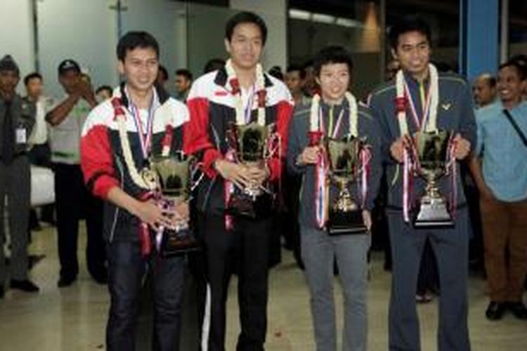 Jura dunia bulu tangkis dari Indonesia, ganda putra Mohammad Ahsan (kiri)/Hendra Setiawan dan ganda campuran Liliyana Natsir/Tontowi Ahmad (kanan), memegang trofi juara dunia dan berpose saat tiba di Bandara Soekarno Hatta, Tangerang, Banten, Senin (12/8/2013).