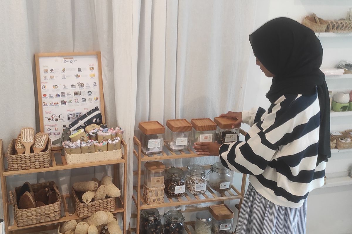 Ratri Sekar Wening (27), menata produk curah di toko Vert Terre di Jalan Kaliurang Km 17A, Sleman, Daerah Istimewa Yogyakarta (DIY), Senin (28/7/2025). 