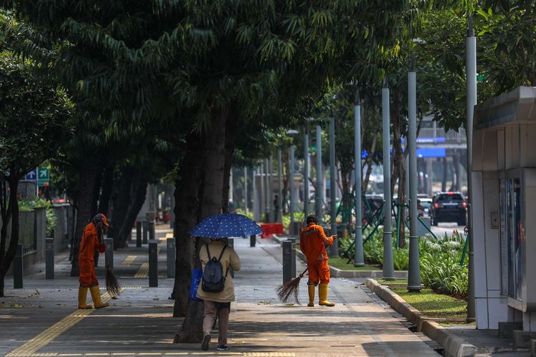Petugas saat membersihkan jalan trotoar di Jalan M.H Thamrin, Jakarta Pusat, Rabu (16/9/2020). PSBB kembali diterapkan tanggal 14 September 2020, berbagai aktivitas kembali dibatasi yakni aktivitas perkantoran, usaha, transportasi, hingga fasilitas umum.