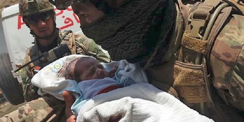 Seorang tentara Afghanistan menggendong bayi yang sudah diselimuti setelah terjadi serangan di Rumah Sakit Nasional Barchi di Kabul, pada Selasa (12/5/2020). Sebanyak 14 orang, termasuk bayi, tewas dalam serangan tersebut, dan terjadi sebelum bom bunuh diri yang membunuh 24 orang dalam sebuah acara pemakaman.