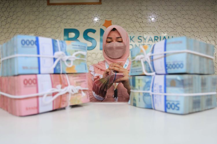 Karyawati Bank Syariah Indonesia (BSI) menghitung uang rupiah di Kantor Cabang Pembantu (KCP) Daud Beureueh, Banda Aceh, Aceh, Jumat (21/1/2022). Otoritas Jasa Keuangan (OJK) menargetkan pertumbuhan kredit perbankan tahun 2022 sebesar 7,5 persen yaitu lebih tinggi dibandingkan tahun sebelumnya sebesar 5,2 persen. ANTARA FOTO/Syifa Yulinnas/nym.