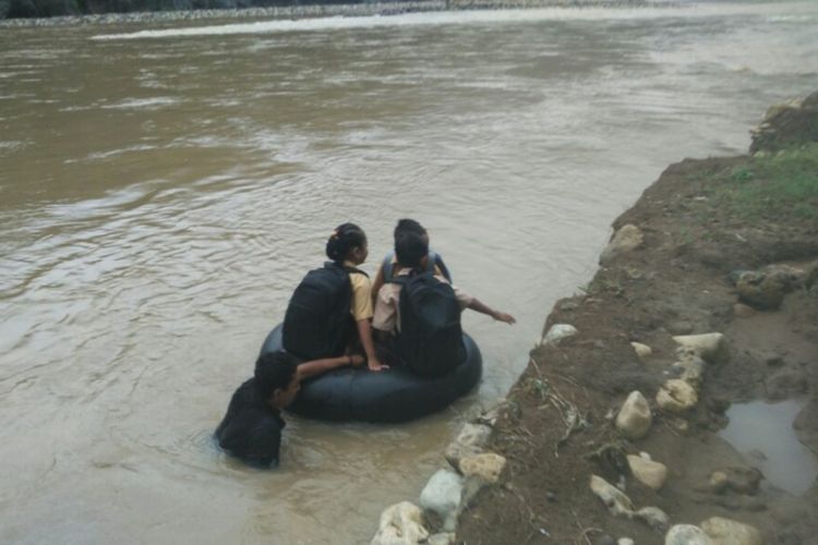 Sumardi menyeberangkan tiga siswa melintasi Sungai Oya di Bantul, Yogyakarta.