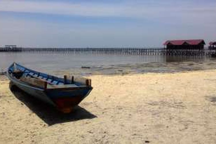 Pantai Pulau Derawan di Kalimantan Timur, yang lapang dan tenang. Airnya biru dan bening. 