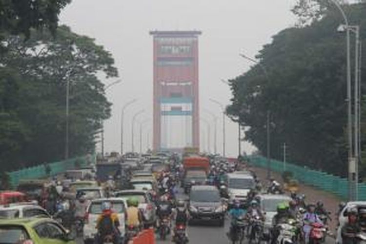 Kabut asap tipis menyelimuti Jembatan Ampera di Kota Palembang, Sumatera Selatan, Jumat siang (14/3). Kabut asap itu merupakan kiriman dari Provinsi Riau yang sedang dilanda kebakaran lahan skala luas.