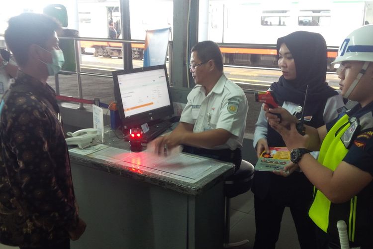 Petugas kesehatan stasiun melakukan pemeriksaan suhu badan penumpang yang masuk ke Stasiun Balapan, Solo, Jawa Tengah, Jumat (6/3/2020).