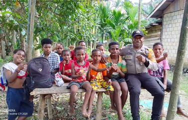 Bhabinkamtibmas Kampung Baburia, Bripka Batias Yikwa, saat bersama-sama anak-anak di Kampung Baburia, Distrik Arso Barat, Kabupaten Keerom, Papua belum lama ini.
