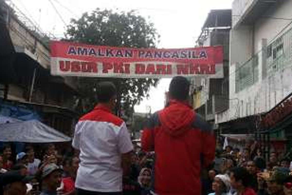 Calon gubernur DKI Jakarta nomor pemilihan tiga Anies Baswedan (kanan, jaket merah) saat berkampanye di hadapan warga RW 02, Kelurahan Karanganyar, Sawah Besar, Jakarta Pusat, Senin (16/1/2017). Tampak di depan panggung tempat dia berkampanye terpasang spanduk bertuliskan 