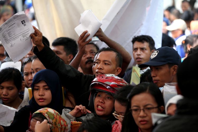 Warga antre menyerahkan berkas untuk pencetakan e-KTP di stan pelayanan dan pencetakan e-KTP di Taman Mini Indonesia Indah (TMII), Jakarta, Jumat (20/10/2017).  Kegiatan yang digelar antara Dinas Kependudukan dan Catatan Sipil DKI bekerja sama dengan Direktorat Jenderal Kependudukan dan Catatan Sipil Kementerian Dalam Negeri ramai diserbu warga yang yang belum memiliki e-KTP.